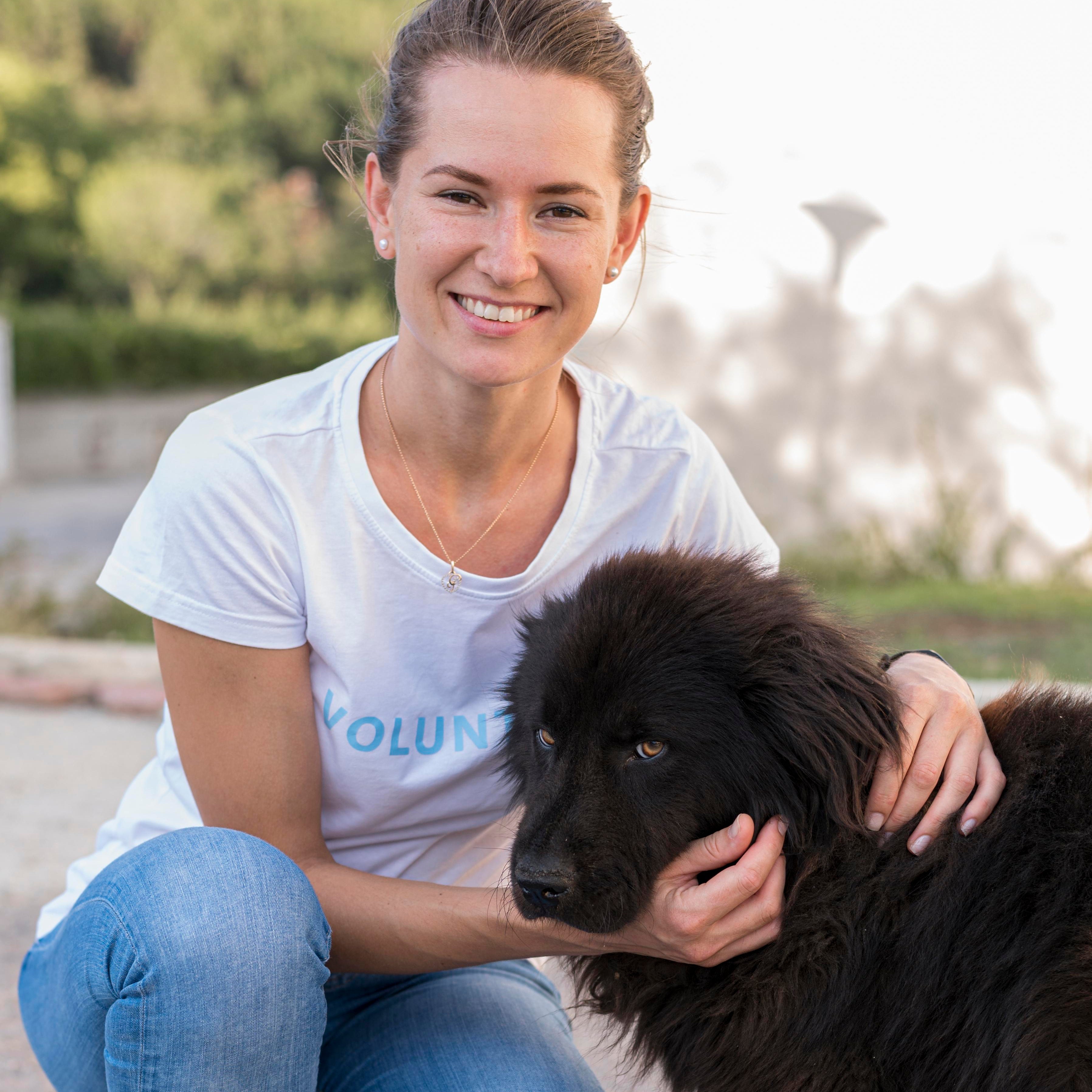 files/smiley-woman-posing-with-fluffy-black-dog-outdoors.jpg